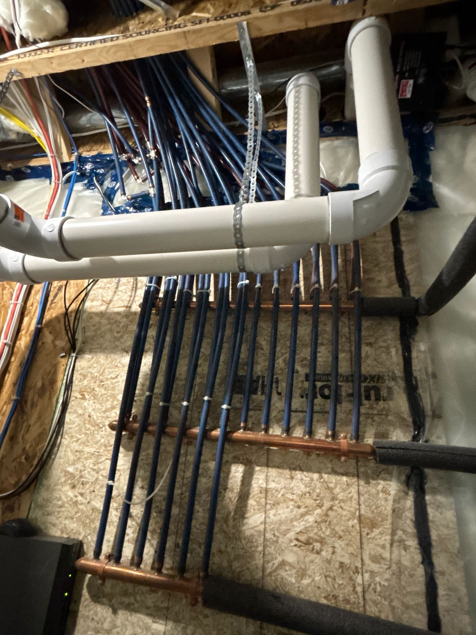 Inspector examining plumbing pipes and fixtures under a sink